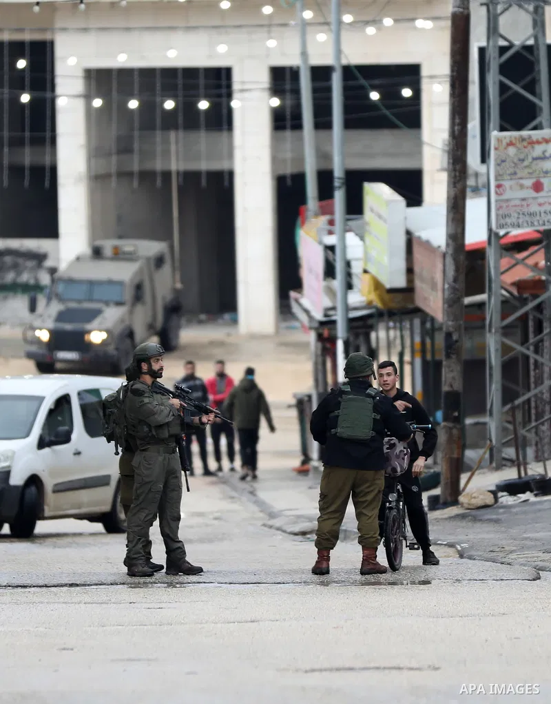 Israeli soldiers gather at a checkpoint at the entrance of the Palestinian town of Huwara, in the occupied West Bank, following a reported shooting attack on an Israeli car, on March 19, 2023. The shooting attack in the...