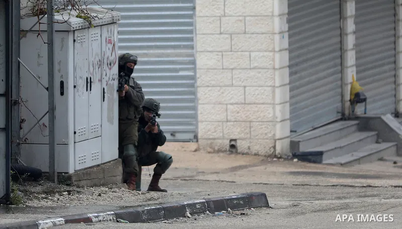 Israeli soldiers gather at a checkpoint at the entrance of the Palestinian town of Huwara, in the occupied West Bank, following a reported shooting attack on an Israeli car, on March 19, 2023. The shooting attack in the...