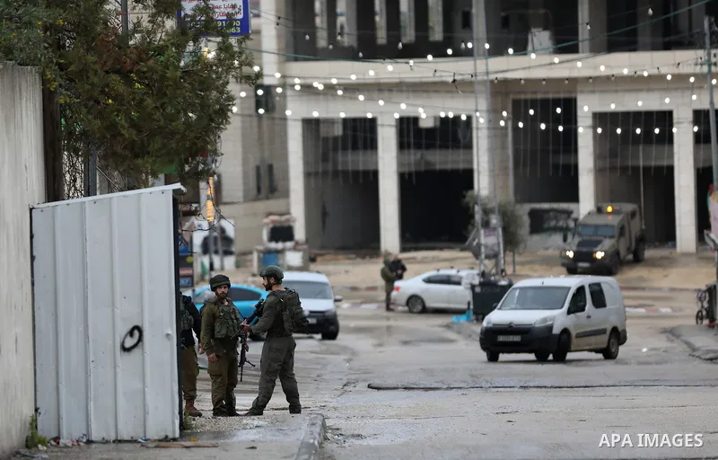Israeli soldiers gather at a checkpoint at the entrance of the Palestinian town of Huwara, in the occupied West Bank, following a reported shooting attack on an Israeli car, on March 19, 2023. The shooting attack in the...