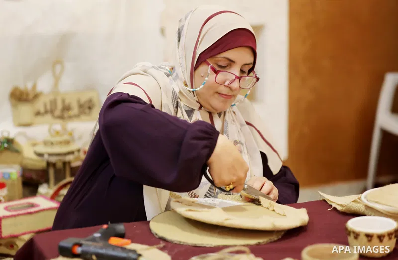 Palestinian woman, Raghda Abu Assi makes handicrafts from burlap at her home in Gaza city on August 14, 2023. A family project in which all family members have been working for more than 27 years, using burlap to revive...