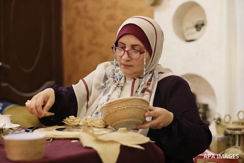 Palestinian woman, Raghda Abu Assi makes handicrafts from burlap at her home in Gaza city on August 14, 2023. A family project in which all family members have been working for more than 27 years, using burlap to revive...