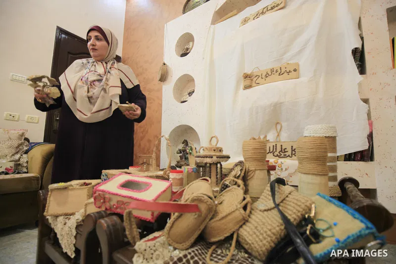 Palestinian woman, Raghda Abu Assi makes handicrafts from burlap at her home in Gaza city on August 14, 2023. A family project in which all family members have been working for more than 27 years, using burlap to revive...