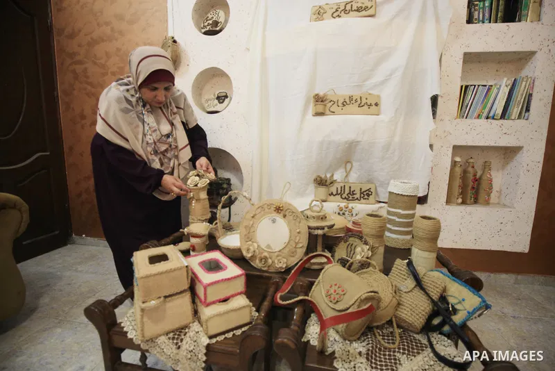 Palestinian woman, Raghda Abu Assi makes handicrafts from burlap at her home in Gaza city on August 14, 2023. A family project in which all family members have been working for more than 27 years, using burlap to revive...