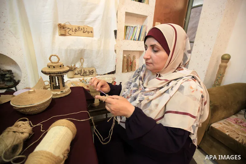 Palestinian woman, Raghda Abu Assi makes handicrafts from burlap at her home in Gaza city on August 14, 2023. A family project in which all family members have been working for more than 27 years, using burlap to revive...