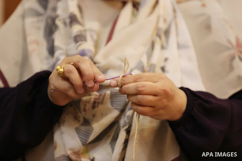 Palestinian woman, Raghda Abu Assi makes handicrafts from burlap at her home in Gaza city on August 14, 2023. A family project in which all family members have been working for more than 27 years, using burlap to revive...