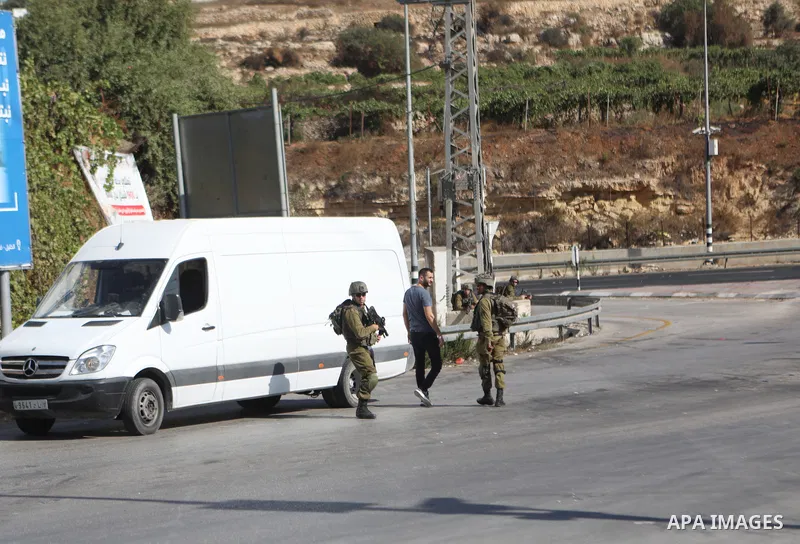 Israeli soldiers search a Palestinian's car at a checkpoint in the West bank city of Hebron on August 22, 2023, near the Israeli settlement of Beit Haggi where a settler killed a day earlier in a shooting attack resided....