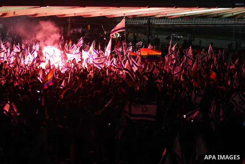 27 March 2023, Israel, Tel Aviv: Israeli anti-government protesters light flares as they take to the streets, following Netanyahu's dismissal of Defence Minister Galant. Angry protests broke out in Tel Aviv on Sunday nig...