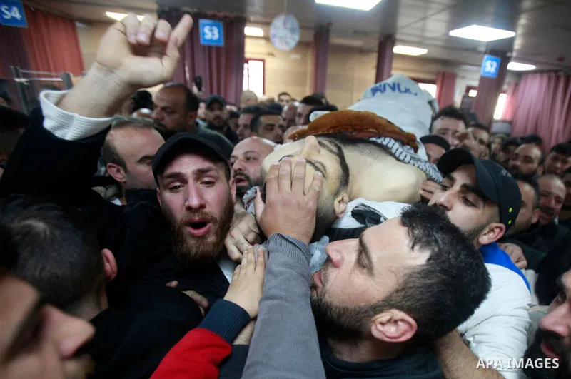 Palestinian relatives carry the body of Mohammed Abu Bakr, who was killed during clashes with the Israeli army, mourn outside the Rafidiya hospital in the the West Bank city of Nablus on April 3, 2023. Two Palestinian yo...
