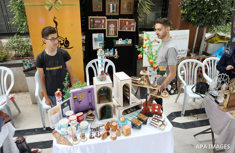 Palestinians attend an exhibition of handicrafts "Jafra Bazaar", in the West Bank city of Hebron on July 10, 2023. Photo by Mamoun Wazwaz \ apaimages