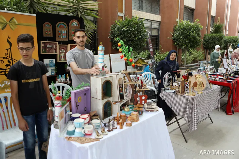 Palestinians attend an exhibition of handicrafts "Jafra Bazaar", in the West Bank city of Hebron on July 10, 2023. Photo by Mamoun Wazwaz \ apaimages