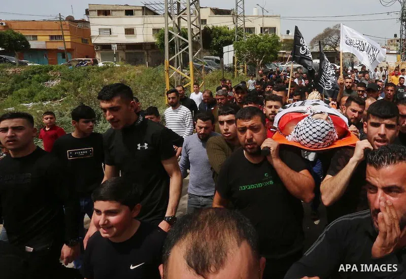 Mourners attend the funeral of Palestinian teenager Mohamed Fayez Balhan, 15, who was killed during a Israeli raid in the Aqabat Jaber camp for Palestinian refugees near Jericho in the West Bank on April 10, 2023. Photo...
