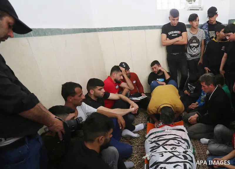Mourners attend the funeral of Palestinian teenager Mohamed Fayez Balhan, 15, who was killed during a Israeli raid in the Aqabat Jaber camp for Palestinian refugees near Jericho in the West Bank on April 10, 2023. Photo...