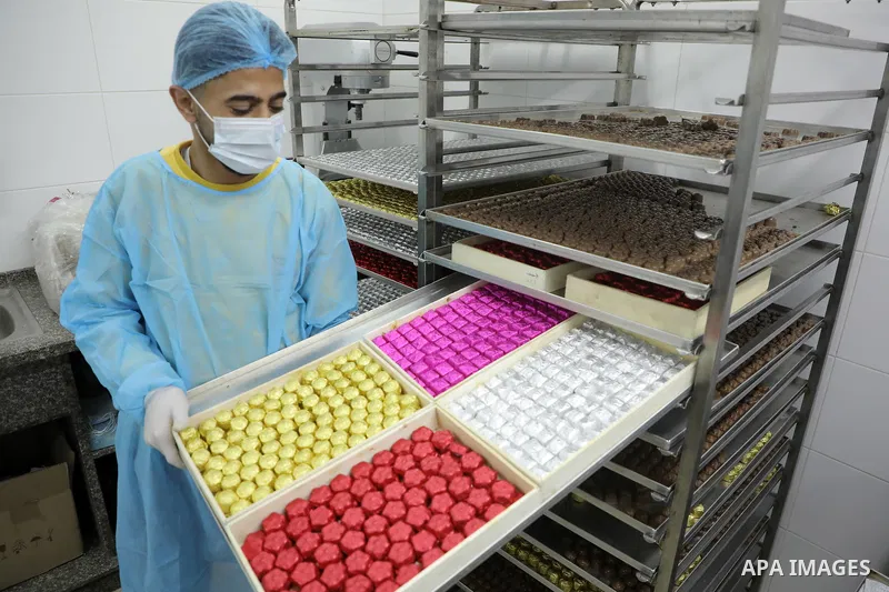 Palestinian workers prepare chocolate for the Eid al-Fitr festival at a chocolate factory in Gaza city on April 12, 2023. Eid al-Fitr is the ended of the holy month of Ramadan by praying during the night time and fasting...