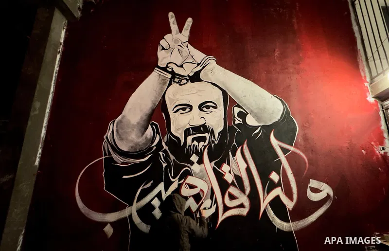 Palestinian artists work by a mural shows jailed Fatah leader Marwan Barghouti, in Jabalia refugee camp in the northern Gaza Strip on April 13, 2023. Marwan Barghouti, born in the West Bank village of Kobar in 1962, is a...
