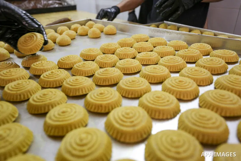 Palestinians prepare traditional date-filled cakes ahead of the Muslim festival of Eid al-Fitr which mart the end of the holy month of Ramadan, in the West Bank city of Nablus on April 19, 2023. Photo by Shadi Jarar'ah\...