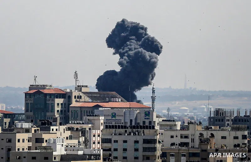A plume of smoke rises above buildings in Gaza City during an israeli air strike on May 11, 2023. Israel and Gaza militants traded more heavy fire today, the third day of the worst escalation of violence in months that h...