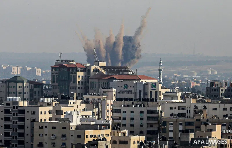 A plume of smoke rises above buildings in Gaza City during an israeli air strike on May 11, 2023. Israel and Gaza militants traded more heavy fire today, the third day of the worst escalation of violence in months that h...