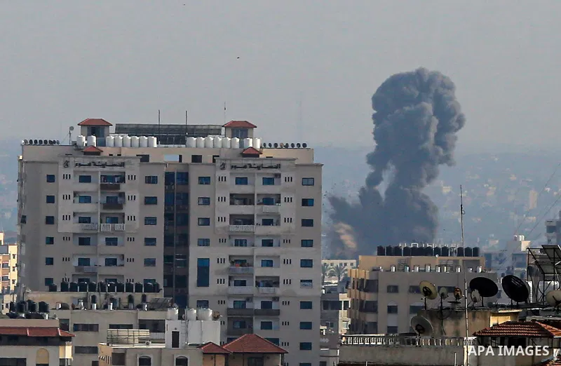 A plume of smoke rises above buildings in Gaza City during an israeli air strike on May 11, 2023. Israel and Gaza militants traded more heavy fire today, the third day of the worst escalation of violence in months that h...