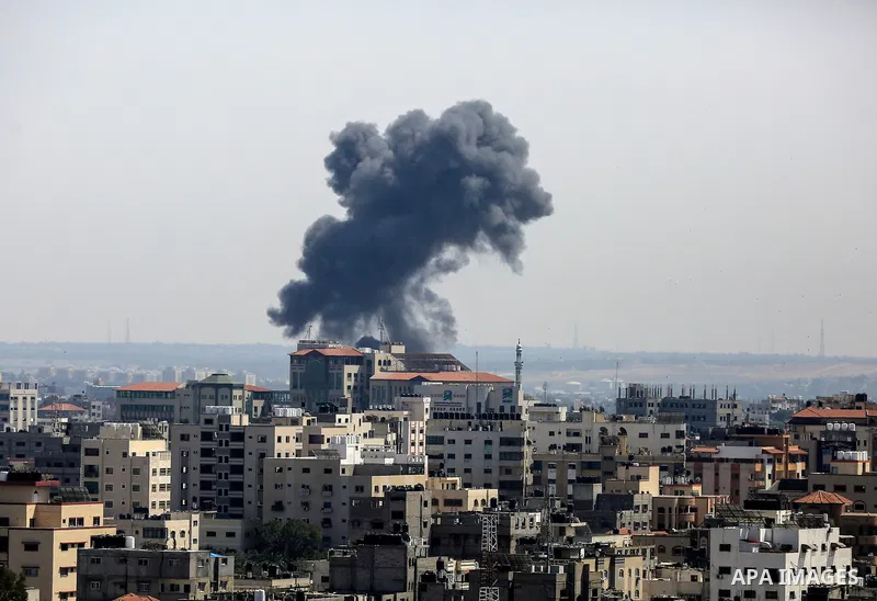 A plume of smoke rises above buildings in Gaza City during an israeli air strike on May 11, 2023. Israel and Gaza militants traded more heavy fire today, the third day of the worst escalation of violence in months that h...