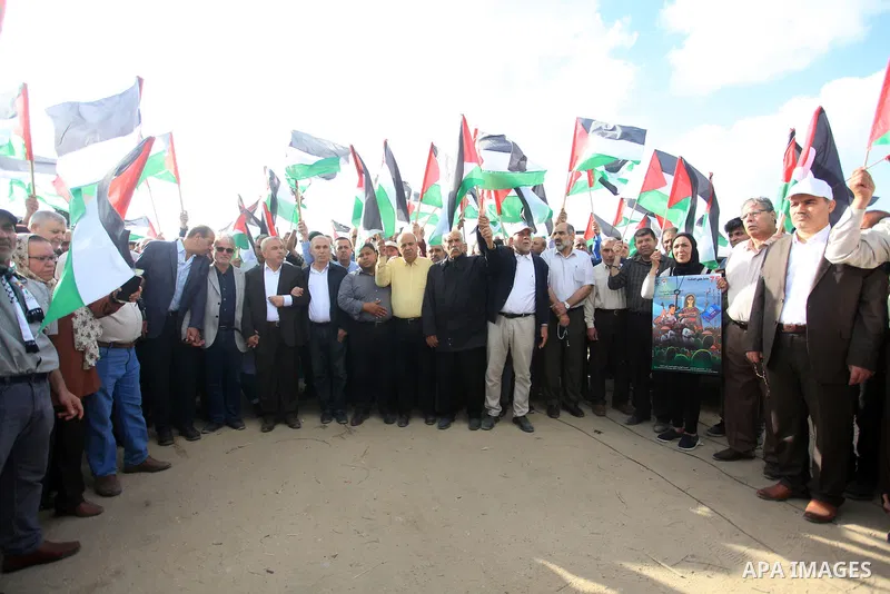 Protesters gather during a Palestinian 'flag march' demonstration along the border with Israel east of Gaza city in response to the annual Israeli flag march marking 'Jerusalem Day' commemorating the old city's capture b...
