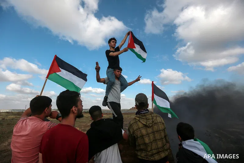 Protesters gather during a Palestinian 'flag march' demonstration along the border with Israel east of Gaza city in response to the annual Israeli flag march marking 'Jerusalem Day' commemorating the old city's capture b...