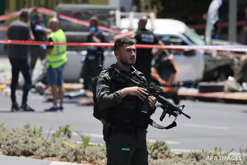 04 July 2023, Israel, Tel-aviv: Israeli security and emergency personnel inspect the site of a car-ramming attack in Tel Aviv. Several people have been injured in a suspected attack in which a car drove into a group of p...