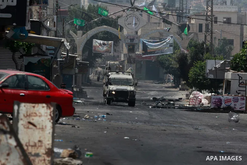An Israeli armoured vehicle is stationed at the entrance of the Jenin refugee camp in the occupied West Bank during an ongoing military operation on July 4, 2023. Israel's biggest military operation for years in the occu...