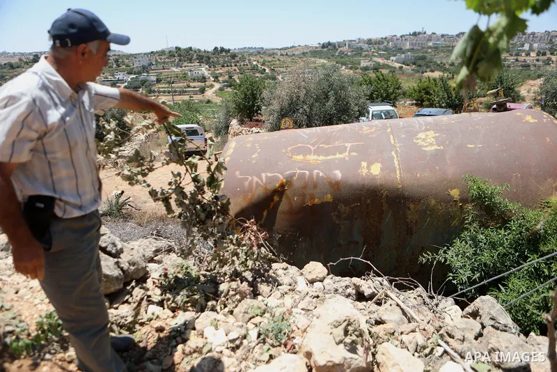 Palestinian farmers inspect grapevines following Israeli settlers attack, in the West Bank city of Hebron on July 17, 2023. The West Bank was seized by Israel in the 1967 Middle East war. Despite international criticism,...