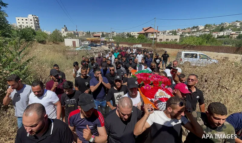 Mourners carry the body of Palestinian Mohammed al-Bayyed who was killed during clashes with Israeli forces while a protest against Israeli settlements during his funeral at Jalazoun refugee camp in the West Bank city of...