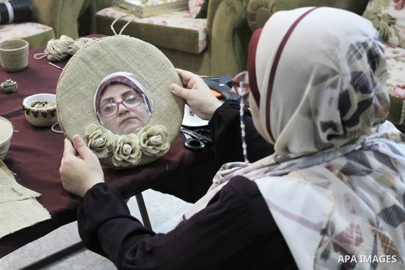 Palestinian woman, Raghda Abu Assi makes handicrafts from burlap at her home in Gaza city on August 14, 2023. A family project in which all family members have been working for more than 27 years, using burlap to revive...
