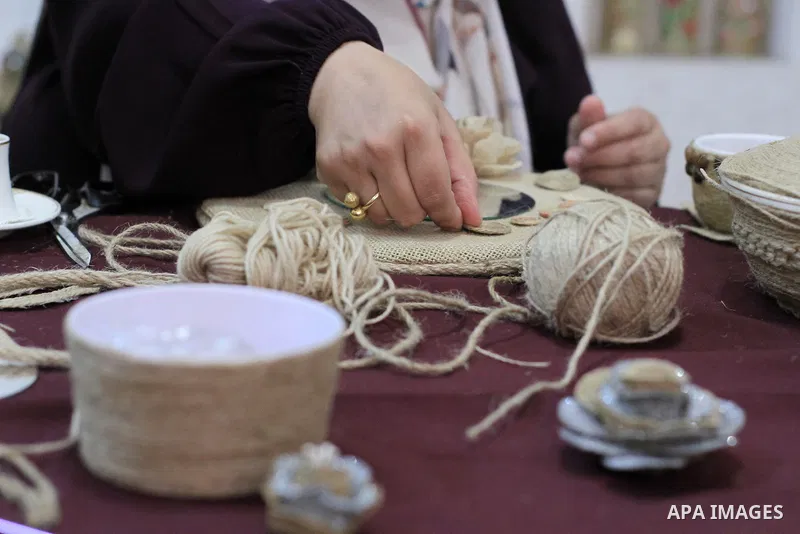 Palestinian woman, Raghda Abu Assi makes handicrafts from burlap at her home in Gaza city on August 14, 2023. A family project in which all family members have been working for more than 27 years, using burlap to revive...
