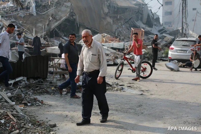 Palestinians inspect the ruins of Watan Tower destroyed in Israeli airstrikes in Gaza city, on October 8, 2023. Fighting between Israeli forces and the Palestinian militant group Hamas raged on October 8, with hundreds k...