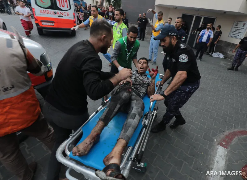 Medics transport wounded man into at al-Shifa hospital following Israeli strikes in Gaza City on October 09, 2023. Israel said it recaptured Gaza border areas from Hamas as the war's death toll passed 3,000 on October 10...