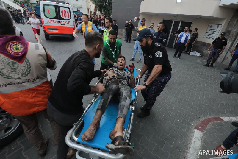 Medics transport wounded man into at al-Shifa hospital following Israeli strikes in Gaza City on October 09, 2023. Israel said it recaptured Gaza border areas from Hamas as the war's death toll passed 3,000 on October 10...