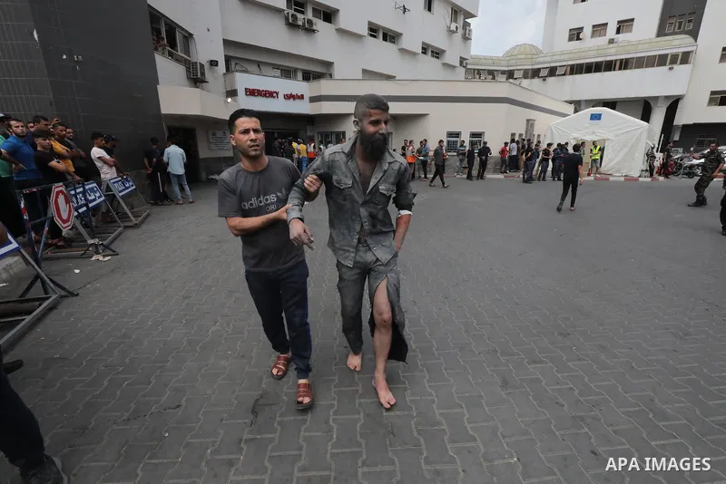 Medics transport wounded man into at al-Shifa hospital following Israeli strikes in Gaza City on October 09, 2023. Israel said it recaptured Gaza border areas from Hamas as the war's death toll passed 3,000 on October 10...