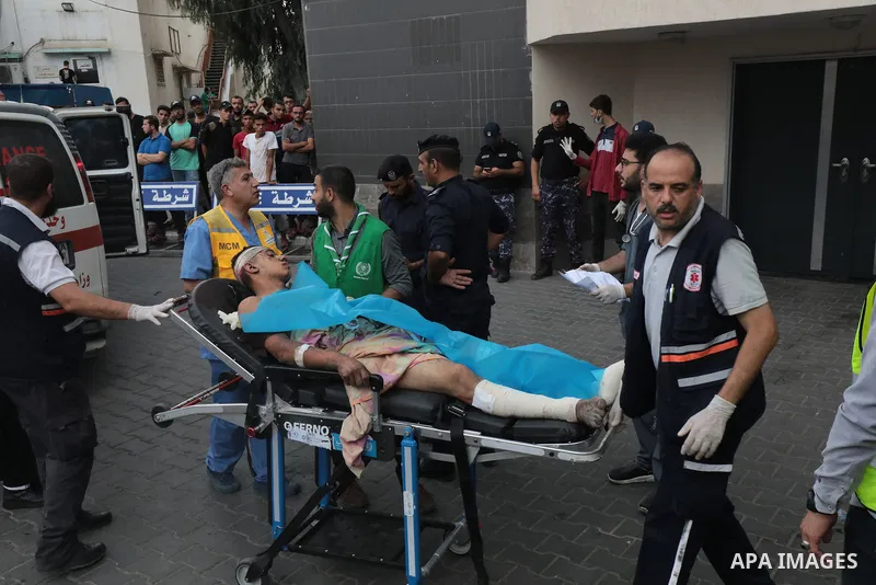 Medics transport wounded man into at al-Shifa hospital following Israeli strikes in Gaza City on October 09, 2023. Israel said it recaptured Gaza border areas from Hamas as the war's death toll passed 3,000 on October 10...