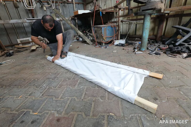 Palestinians make a traditional stretcher to transport the injured and dead at Al-Aqsa Hospital in Dair al-Balah, on 22 October 2023. Photo by Omar Ashtawy\ apaimages