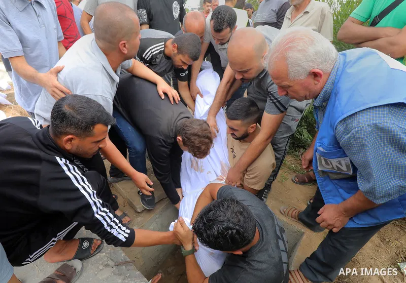 People bury bodies of killed Palestinians in the old mass grave, prepared in the city cemetery since there is no empty space in some cemeteries due to the increasing number of dead as Israeli airstrikes continues in Al-Z...