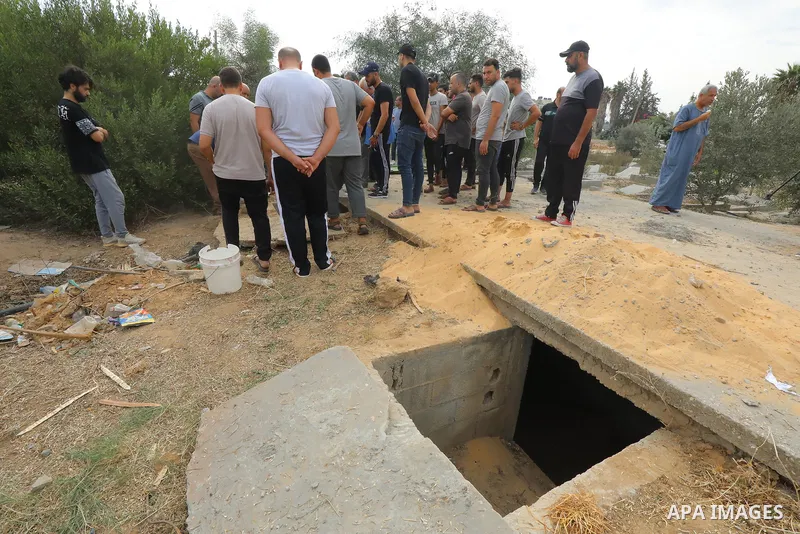 People bury bodies of killed Palestinians in the old mass grave, prepared in the city cemetery since there is no empty space in some cemeteries due to the increasing number of dead as Israeli airstrikes continues in Al-Z...