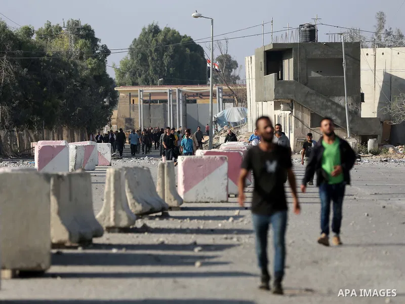 Palestinian workers, who were stranded in Israel since the October 7 attacks, walk near the Rafah border crossing with Egypt as they make their way to cross back into the Gaza Strip at the Kerem Shalom commercial border...