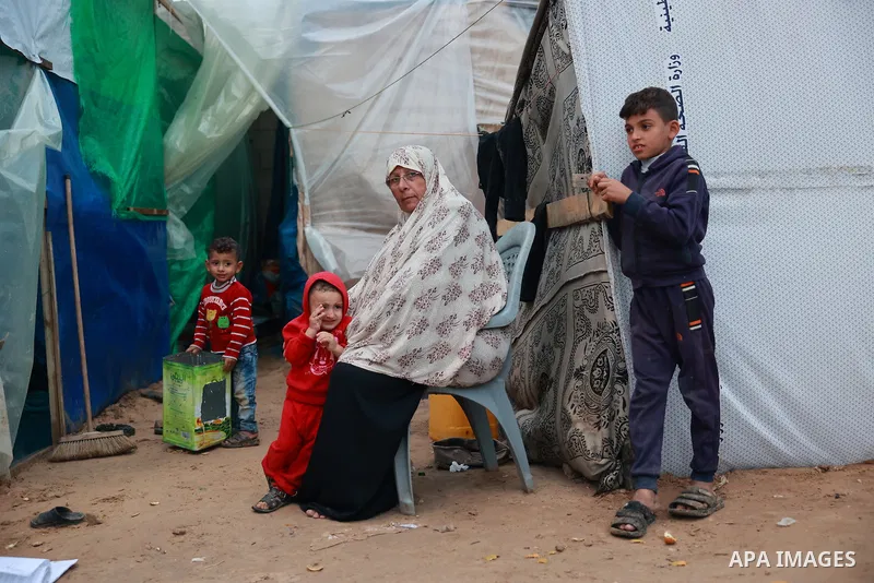 Palestinian families, who migrated to the vicinity of Al-Aqsa Martyrs Hospital due to Israeli attacks, struggle with bad weather conditions at the makeshift tents they set up in Deir Al-Balah, Gaza on November 27, 2023....