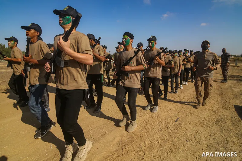 Palestinian youths brandishing fake rifles, parade during a military-style summer camp, organised annually by the Islamic Jihad movement during the school holiday, in Khan Yunis in the southern Gaza Strip, on June 22, 20...