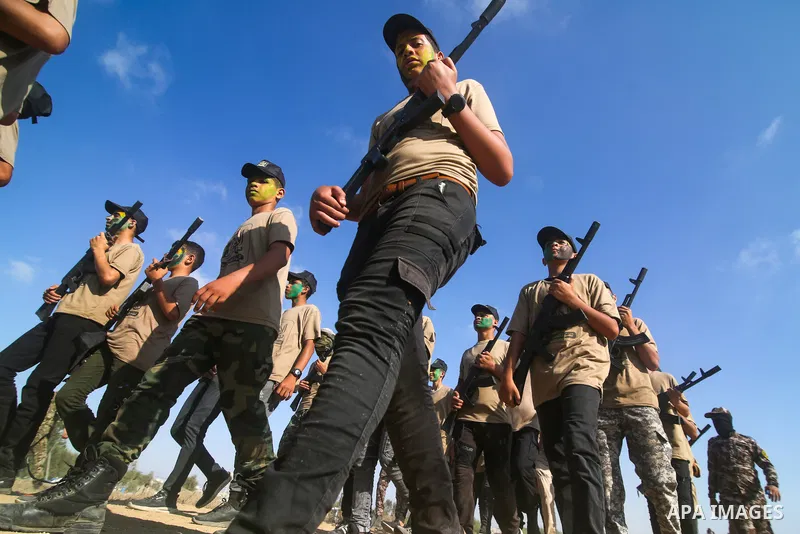 Palestinian youths brandishing fake rifles, parade during a military-style summer camp, organised annually by the Islamic Jihad movement during the school holiday, in Khan Yunis in the southern Gaza Strip, on June 22, 20...
