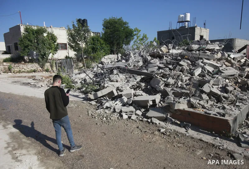 People gather amidst debris after Israeli forces demolished the house of a Palestinian prisoner Younes Hilan in the village of Hajja, east of the West Bank city of Qalqilya on May 3, 2023. Local sources told the Israeli...