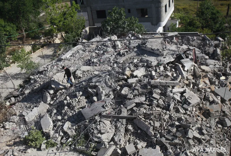 People gather amidst debris after Israeli forces demolished the house of a Palestinian prisoner Younes Hilan in the village of Hajja, east of the West Bank city of Qalqilya on May 3, 2023. Local sources told the Israeli...