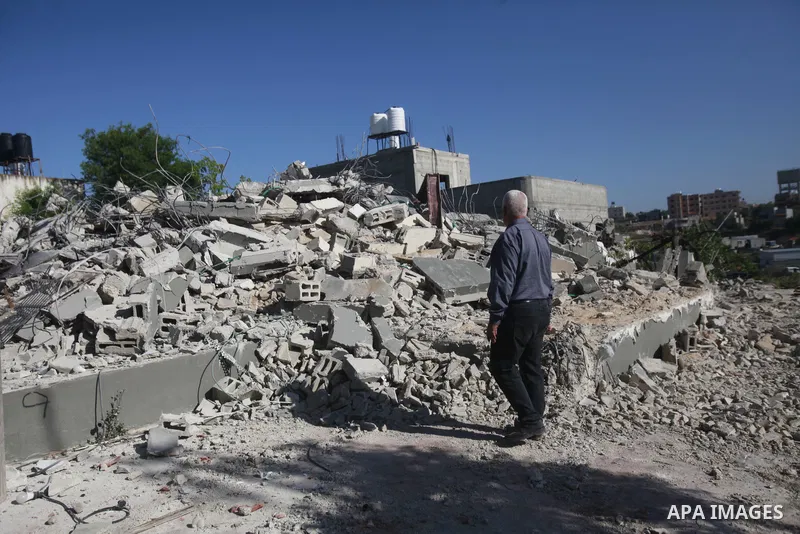 People gather amidst debris after Israeli forces demolished the house of a Palestinian prisoner Younes Hilan in the village of Hajja, east of the West Bank city of Qalqilya on May 3, 2023. Local sources told the Israeli...