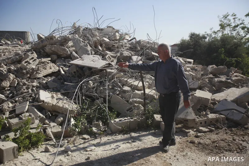 People gather amidst debris after Israeli forces demolished the house of a Palestinian prisoner Younes Hilan in the village of Hajja, east of the West Bank city of Qalqilya on May 3, 2023. Local sources told the Israeli...