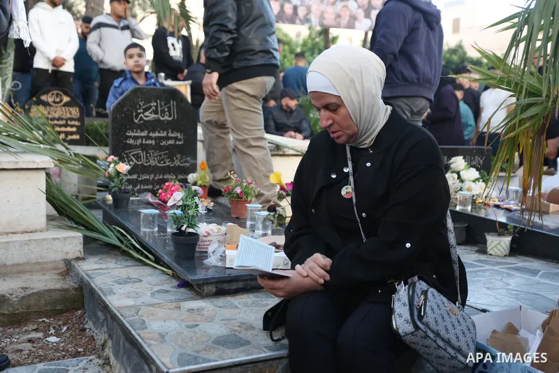Palestinian families of people who were killed by Isareli forces visit graves of their relatives at a cemetery during the first day of Eid al-Fitr, in the west bank city of Nablus, on April 21, 2023. Muslims across the w...