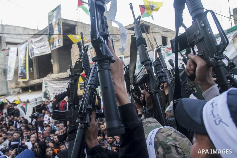 Palestinian gunmen of the Al-Aqsa Martyrs Brigades faction affiliated with the Fateh movement, hold their weapons during a military parade, in the Balata refugee camp in the West Bank city of Nablus on March 17, 2023. Ph...