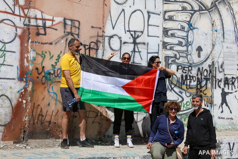 Participants run past a section of Israel's controversial separation barrier during the "Freedom of Movement Palestine Marathon" in Bethlehem in the West Bank on March 10, 2023. Photo by Ahmad Tayem/APAimages